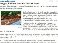 Bagger Erde und eine Art Berliner Mauer